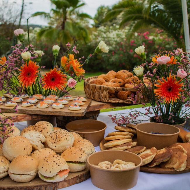 Buffet brunch en extérieur : petits pains, viennoiseries, blinis et compositions florales